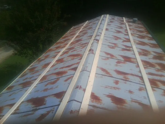 Rusted metal roof panels with new wood purlins before replacement — Storm Damage Roof Repair in Whitesville by Roofing Brothers