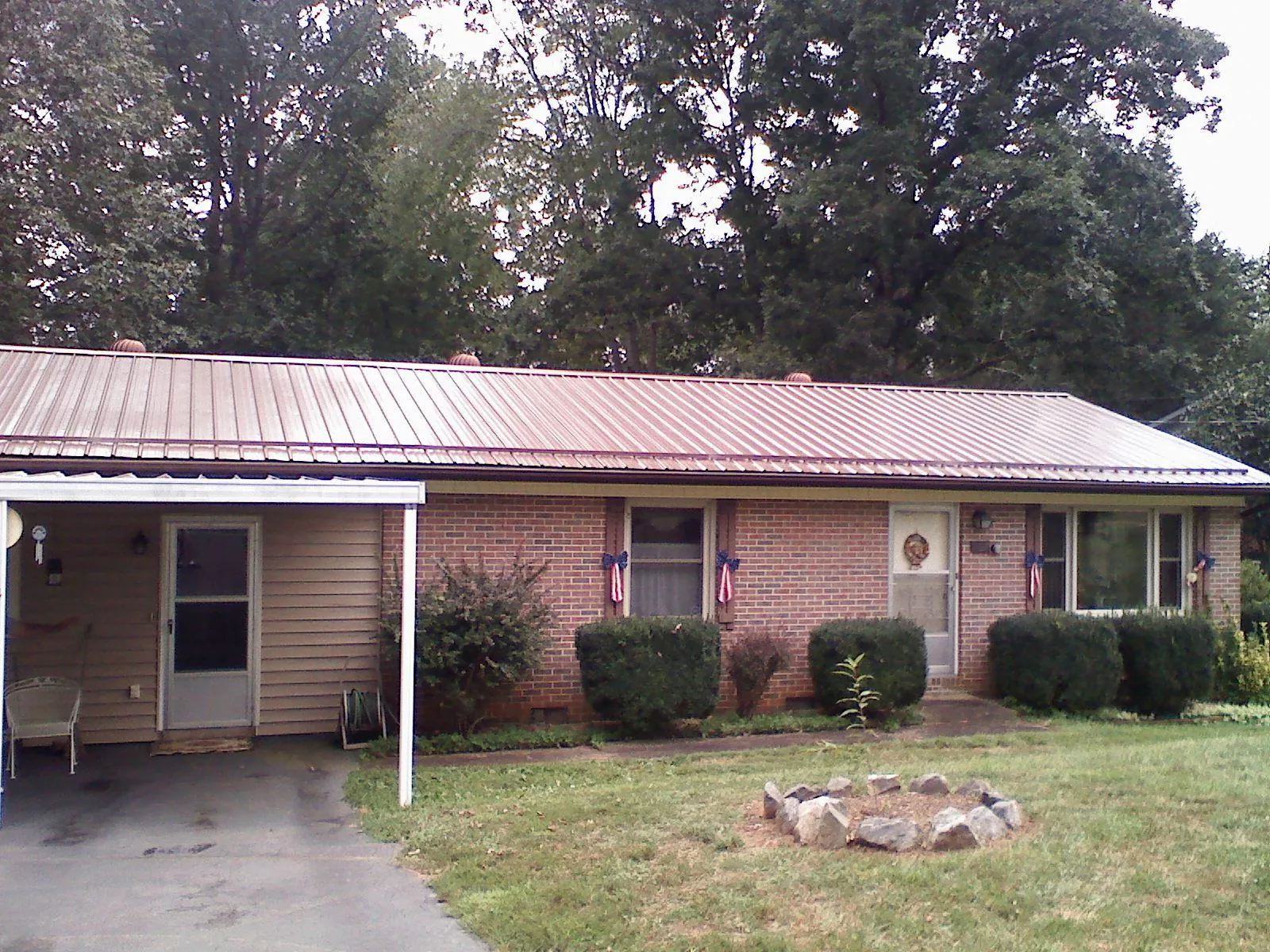 Bronze metal roof and carport on a brick ranch home — Roof Repair work by our crew in Whitesville